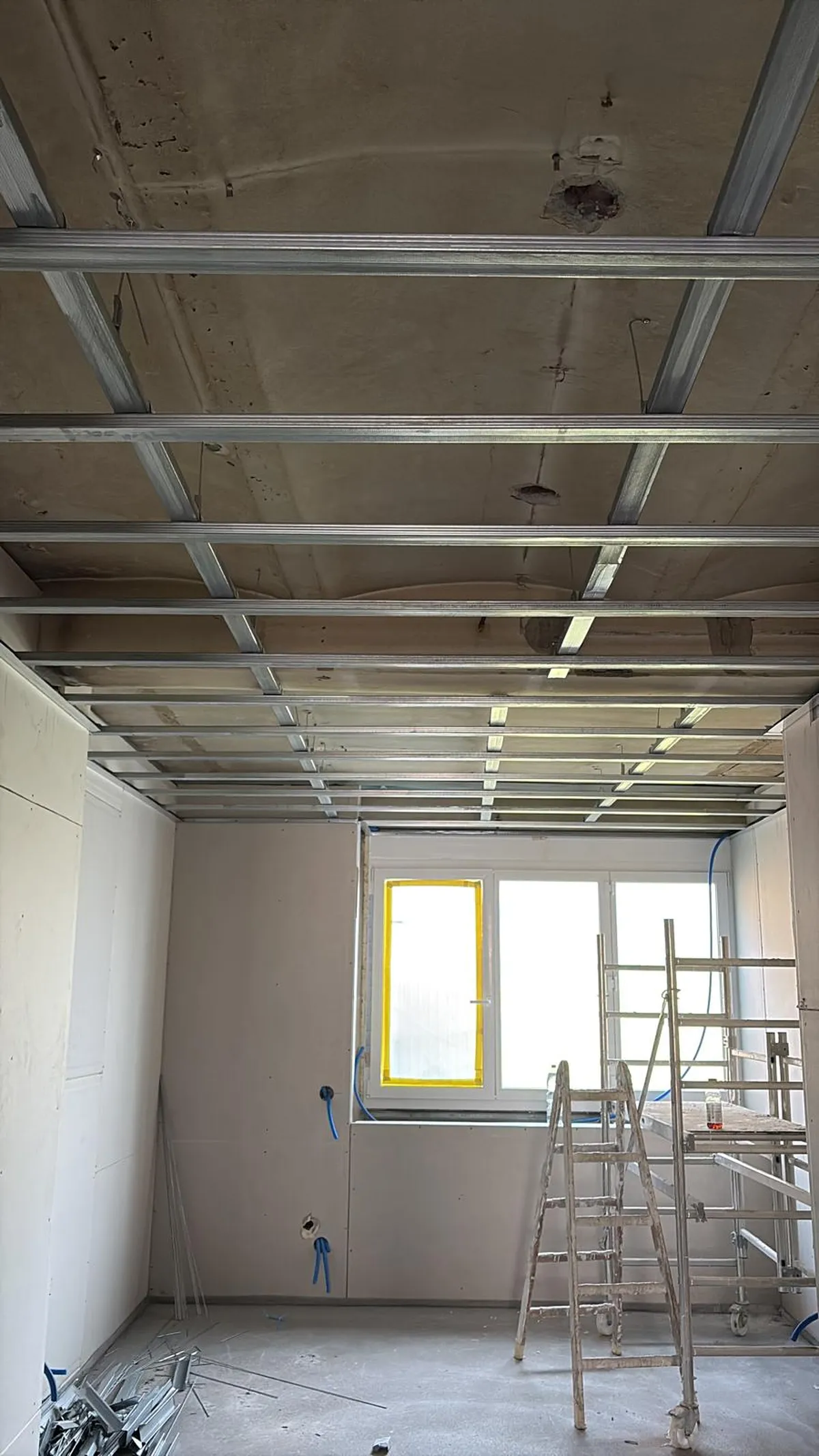 Ossature métallique d'un faux plafond suspendu dans une pièce plaquée, chantier de plâtrerie mené par l'équipe de Peinture Casabene.