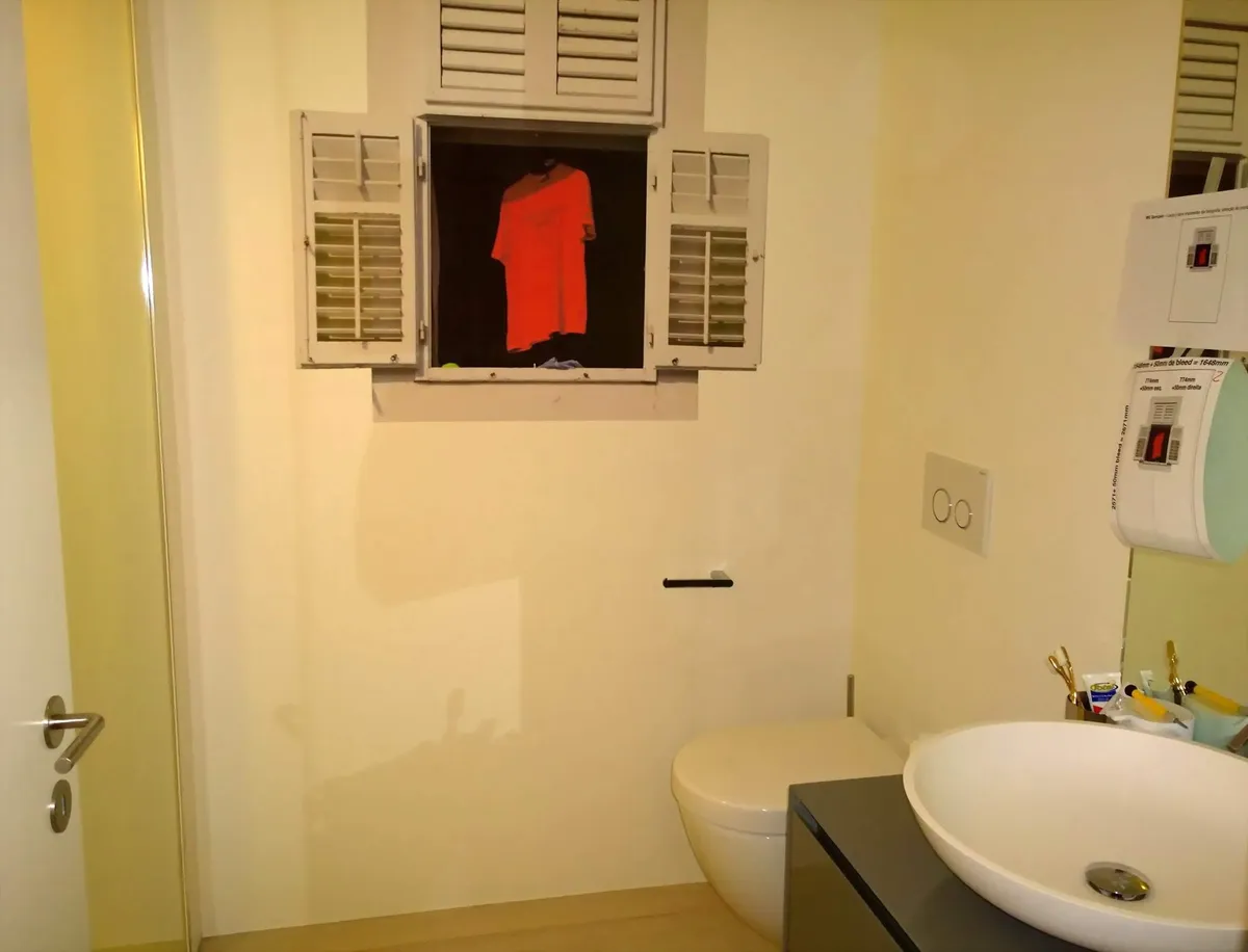 Salle de bain avec une fenêtre à volets factices en papier peint et un lavabo ovale noir, une décoration murale signée Peinture Casabene.