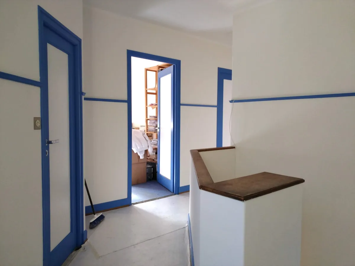 Couloir aux portes à chambranle bleu après peinture des boiseries