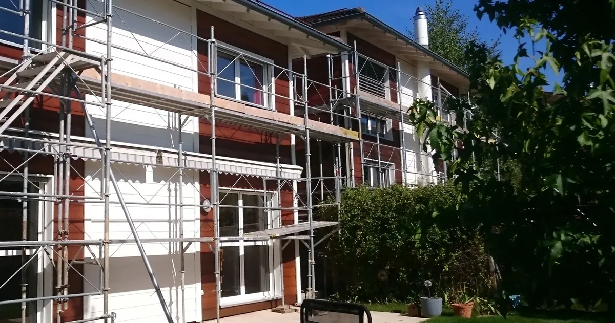 Échafaudage monté sur toute la hauteur d'une façade, chantier de peinture en cours.