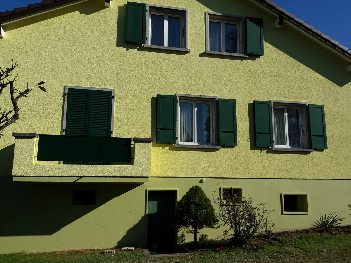 Façade vert tilleul et volets foncés après remise en peinture