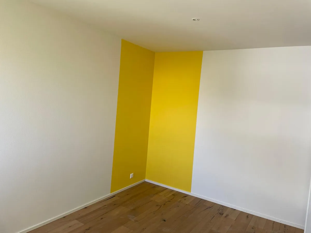 Angle de chambre repeint, raccord net entre deux pans de mur après une reprise localisée.