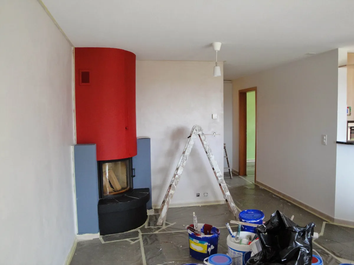 Couloir d'appartement au sol protégé, matériel de peintre en place avant les reprises.