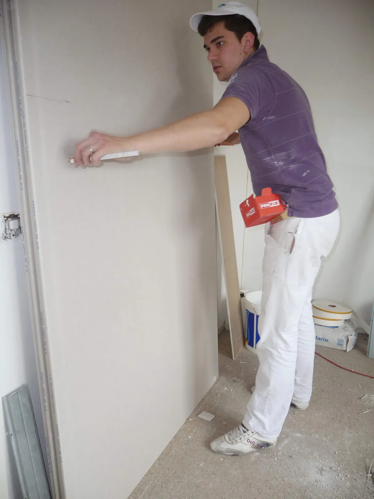 Ouvrier appliquant un enduit de joint sur une plaque de plâtre fraîchement posée, une étape de plâtrerie confiée à l'atelier Peinture Casabene.